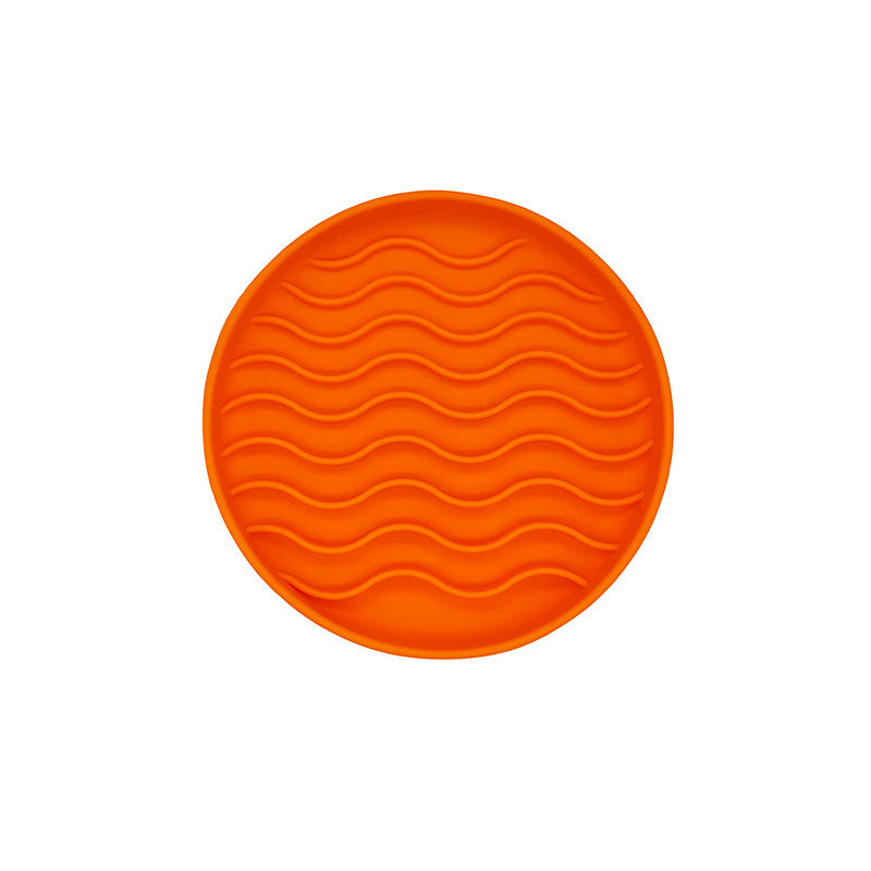 Orange round licking textured mat on a white background