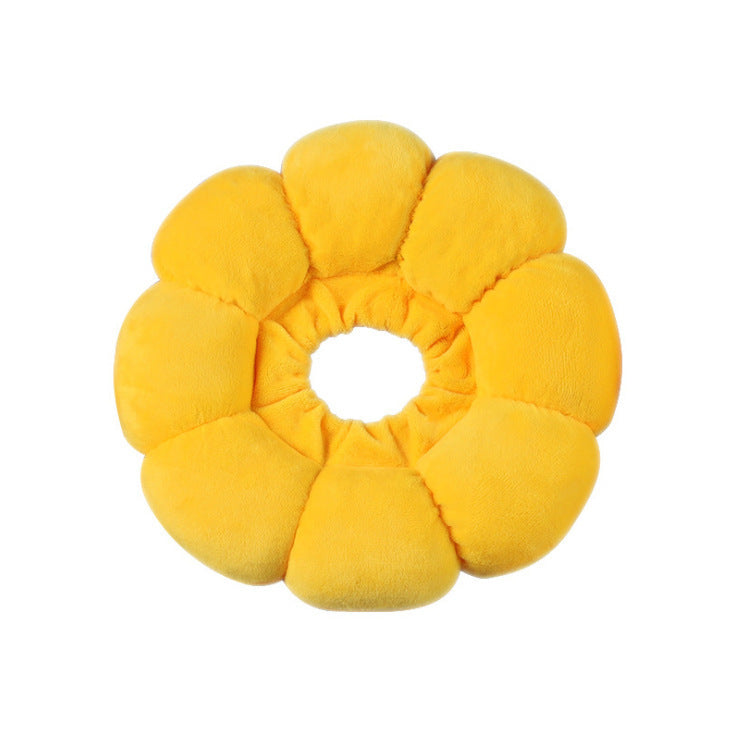 A bright yellow flower-shaped plush cushion collar with soft, padded petals surrounding a circular center, isolated on a white background.