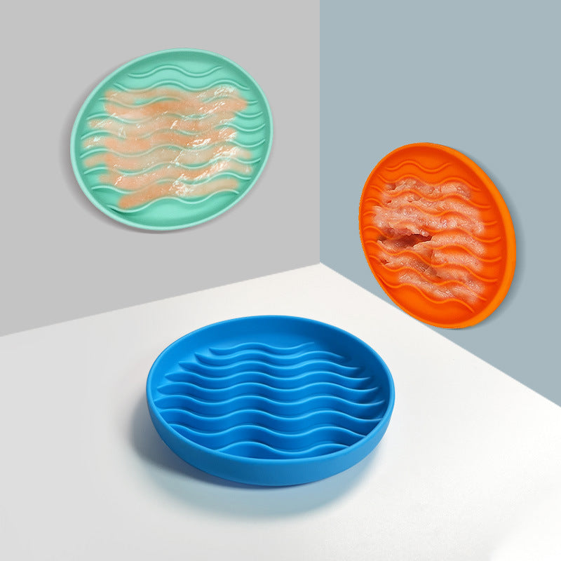 Set of three silicone licking mat with wavy design in teal, orange, and blue on a white surface.