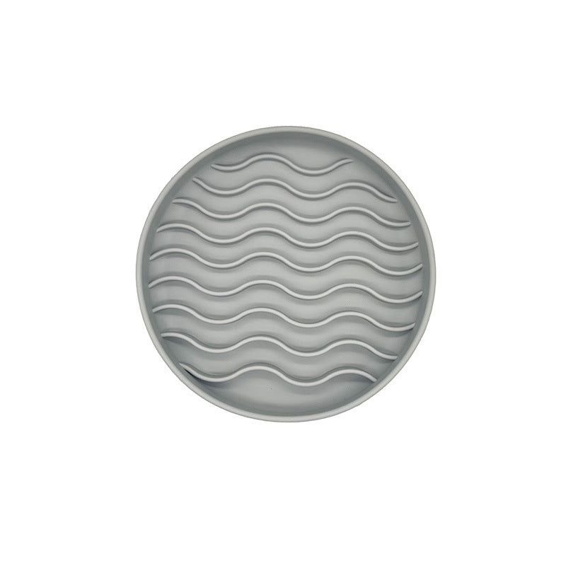 Round gray licking mat for pets with wavy pattern on a white background