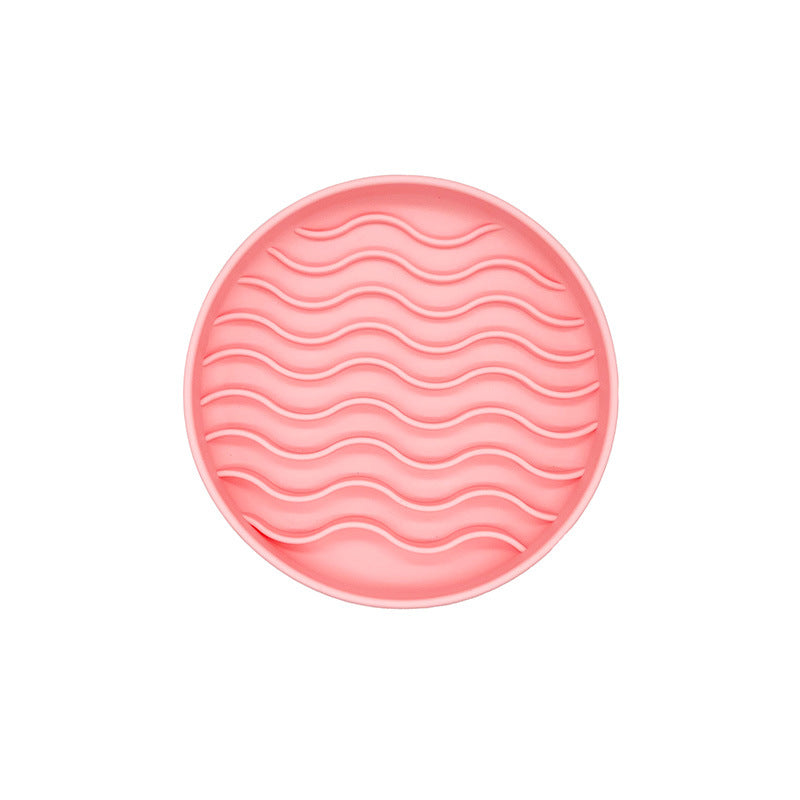 Pink round  licking bowl with wavy pattern on a white background